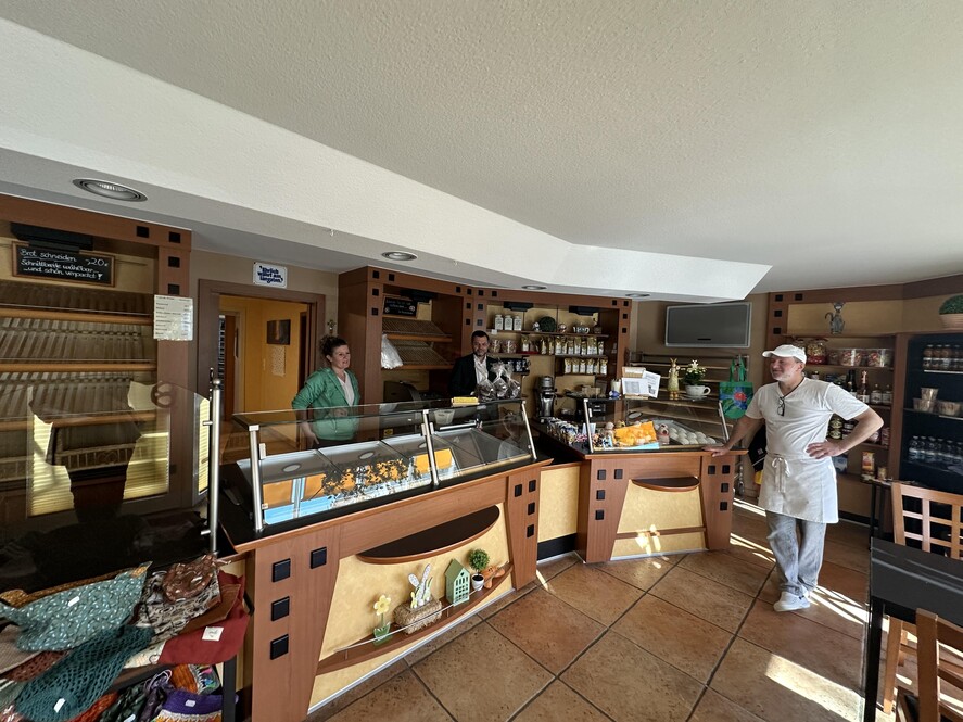 Günter und Anita Rudolf gemeinsam mit Herrn Heck im Verkaufsraum mit dem Stehcafe.