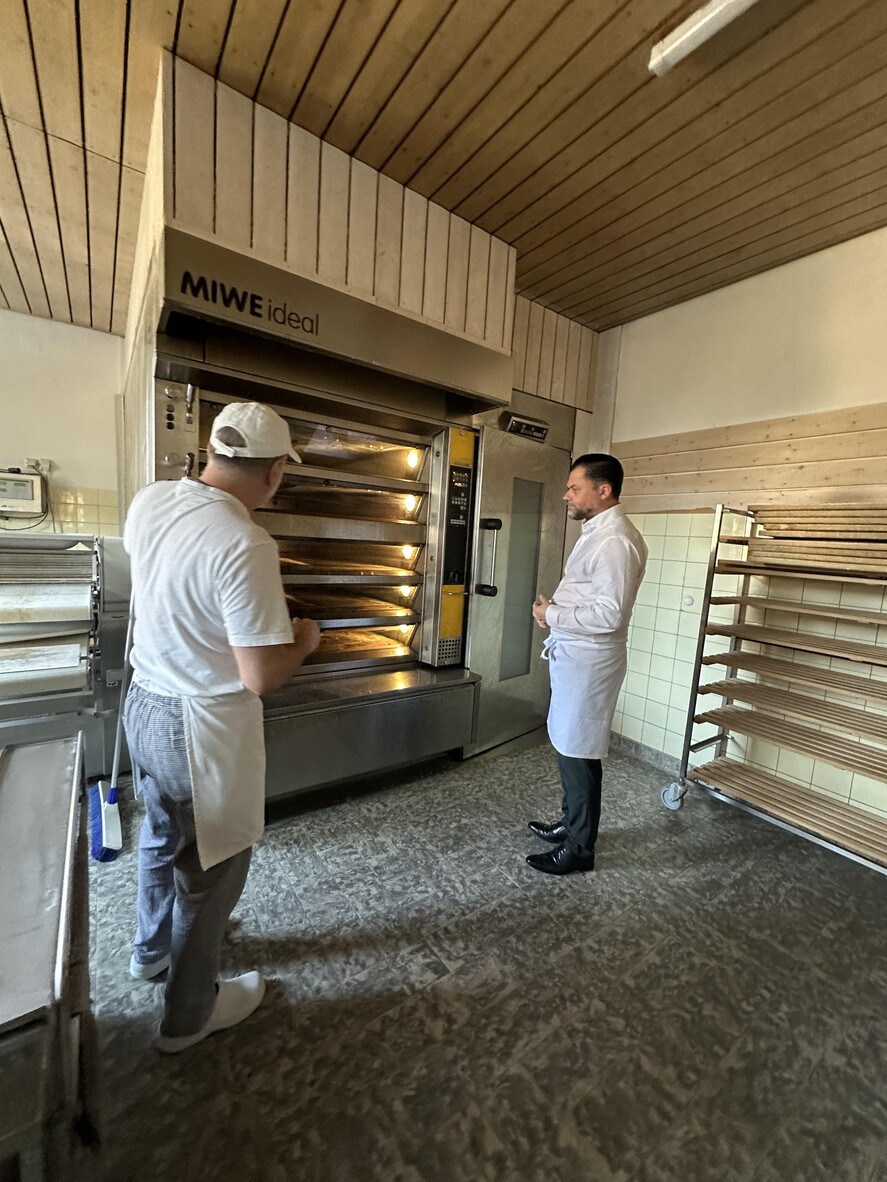 Günter Rudolf erklärt Andreas Heck die Gegebenheiten des Ofens – das Herzstück der Bä-ckerei.
