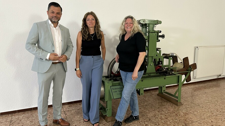 Bürgermeister Andreas Heck gemeinsam mit Susanne Geiger und Petra Huber an einer Reckmaschine von 1938.